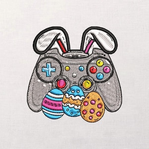 Könnte beinhalten: Gesticktes Design mit einem grauen Videospiel-Controller mit Hasenohren. Der Controller hat bunte Knöpfe und ist mit drei Ostereiern in Blau, Rosa und Orange verziert. Das Design befindet sich auf weißem Hintergrund.