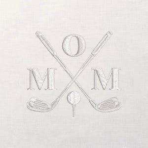 May include: Embroidered design featuring crossed golf clubs, a golf ball on a tee, and the word "MOM" with the letter "O" in the center. The design is in a light gray color on a white background.
