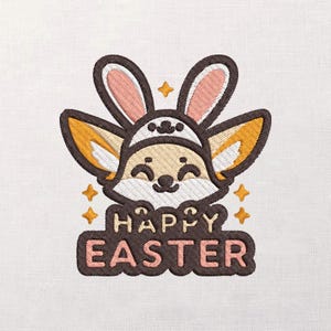 May include: An embroidered design features a cartoon fox wearing a bunny hat, with the words "HAPPY EASTER" below. The fox is light brown with a white face and ears, and the bunny hat is brown with pink and white accents. Gold stars surround the fox.