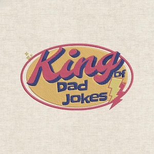 May include: Embroidered patch with the text "King of Dad Jokes" in pink and blue, set within a yellow oval. A yellow lightning bolt graphic is on the right side of the oval. The patch is on a light beige fabric.