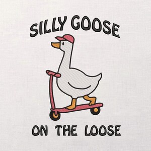 Puede incluir: Diseño bordado de un ganso blanco con gorra roja, montado en un patinete rosa. El texto "SILLY GOOSE" está encima del ganso, con "ON THE LOOSE" debajo. El diseño está sobre un fondo blanco.