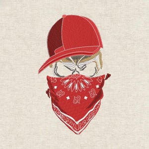 Op de afbeelding: Geborduurd ontwerp van een schedel met een rode baseballpet en een rode bandana. De schedel heeft een strenge uitdrukking, waarbij de bandana het onderste deel van het gezicht bedekt. De pet is schuin en de bandana heeft een paisley patroon.