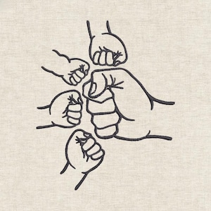 May include: An embroidered design of five clenched fists in black thread on a beige fabric. The fists are arranged in a circular pattern, with detailed outlines. The design has a simple, graphic style.