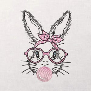 May include: Embroidered image of a bunny with a pink polka dot bow, heart-shaped glasses, and a bubblegum bubble. The bunny's face is detailed with black thread, and the glasses and bow are pink. The bubble is a lighter shade of pink.
