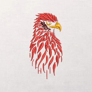 May include: Embroidered design of a red hawk's head and upper body on a white background. The hawk has a yellow beak, yellow eye details, and a red and brown feathered pattern. The design is likely for a patch or embroidery project.