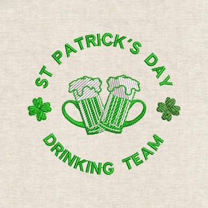May include: Embroidered design featuring two green beer mugs with white foam, surrounded by the text "ST PATRICK'S DAY DRINKING TEAM" and green shamrocks. The design is on a beige fabric.