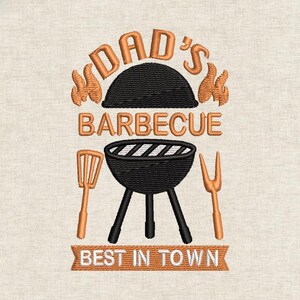 May include: Embroidered design featuring the words "DAD'S BARBECUE" above a black grill with orange flames, spatula, and fork. The phrase "BEST IN TOWN" is displayed below. The design is in orange and black.