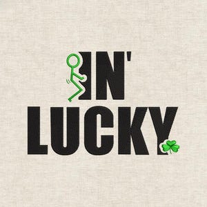Op de afbeelding: Geborduurd ontwerp met de zwarte woorden "IN LUCKY", met een groen stokfiguur en een klavertje vier. De tekst is gecentreerd op een lichtbeige stof, wat een thema voor St. Patrick's Day creëert.