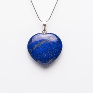 Op de afbeelding: Een zilveren ketting met een hartvormige hanger van blauwe lapis lazuli.