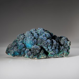 May include: A cluster of blue-green azurite mineral with a rough, textured surface.