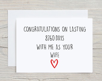 Puede incluir: Tarjeta blanca con texto negro que dice "Felicidades por durar 8760 días conmigo como tu esposa" con un corazón rojo.