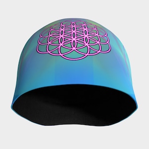 May include: A blue beanie with a colorful gradient and a pink geometric design on the front.