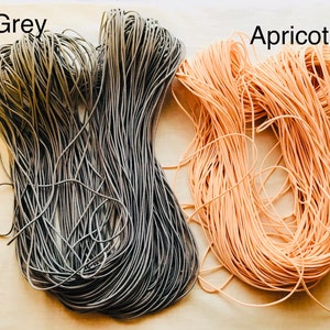 May include: Two spools of elastic cord, one grey and one apricot.