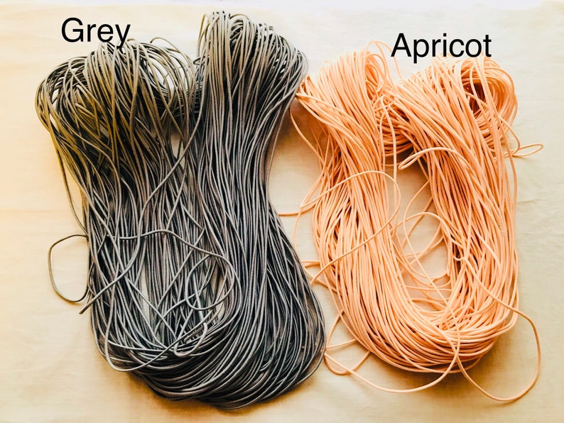 May include: Two spools of elastic cord, one grey and one apricot.