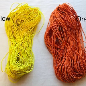 May include: Two spools of elastic cord, one yellow and one orange. The spools are labeled "Yellow" and "Orange".