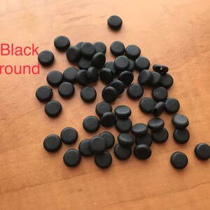 May include: A pile of black round rubber stoppers.