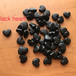 May include: A pile of black heart-shaped plastic beads.