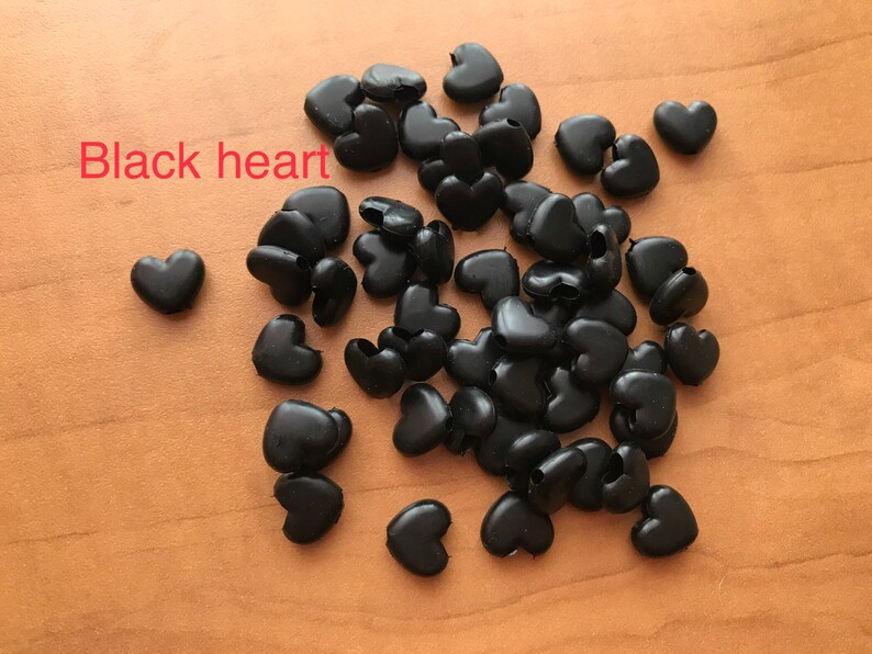 May include: A pile of black heart-shaped plastic beads.