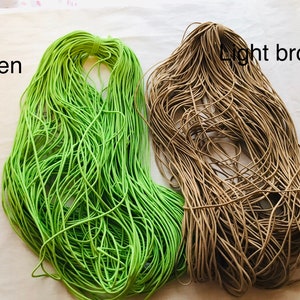 May include: Two spools of elastic cord, one green and one light brown.