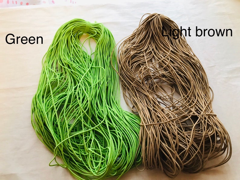 May include: Two spools of elastic cord, one green and one light brown.