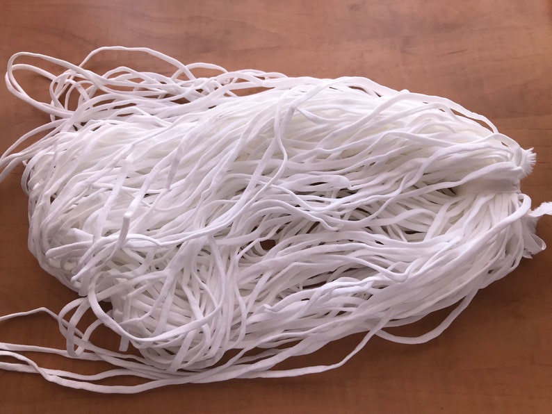 May include: A large pile of white elastic cord, ideal for crafting projects.