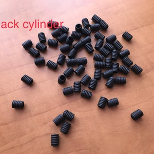 May include: A large quantity of small black rubber cylinder stoppers.