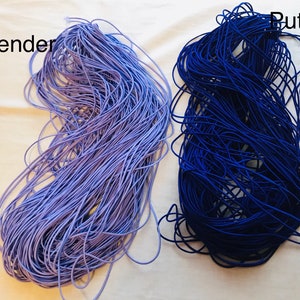 May include: Two spools of elastic cord, one lavender and one dark blue. The spools are labeled "Lavender" and "Purple".
