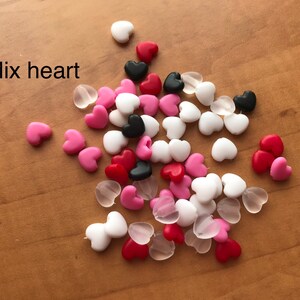 May include: A mix of heart-shaped beads in pink, red, white, black, and clear.  Mix heart.