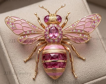 Op de afbeelding: Een gouden bijenbroche met roze emaille vleugels ingelegd met heldere stenen, een centrale ovale roze edelsteen op het borststuk en een gesegmenteerd achterlijf versierd met donkerroze vierkante stenen en gouden banden, tekst ZH Jewelry zichtbaar.