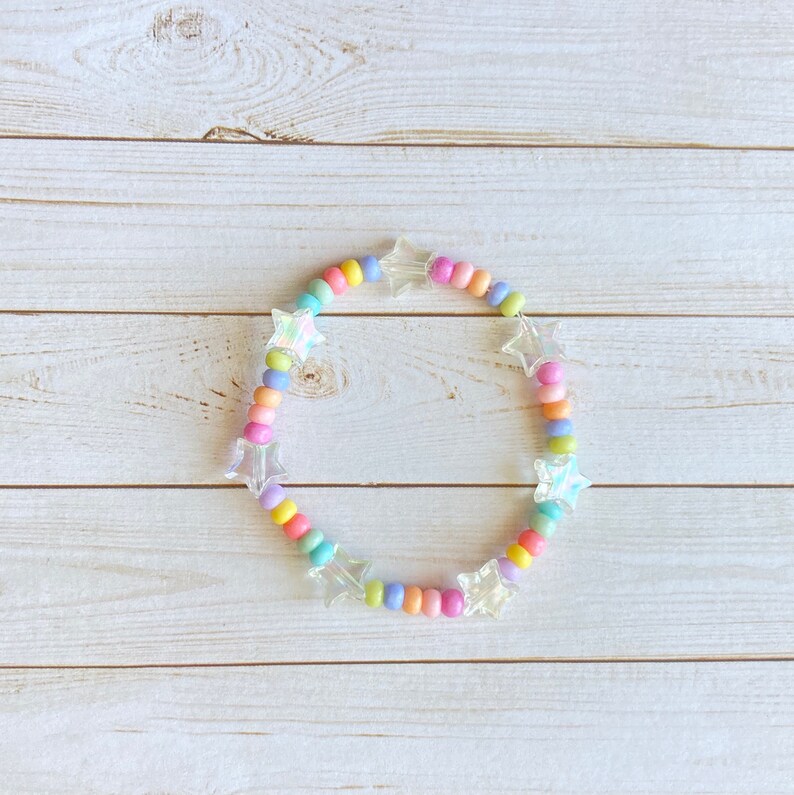 May include: A pastel rainbow colored beaded bracelet with iridescent star-shaped charms.