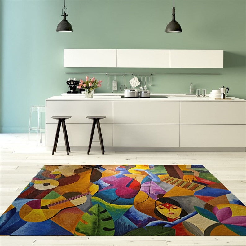May include: Abstract area rug with a colorful design featuring geometric shapes, musical instruments, and a woman's face. The rug is in a modern kitchen with white cabinets and a green wall.