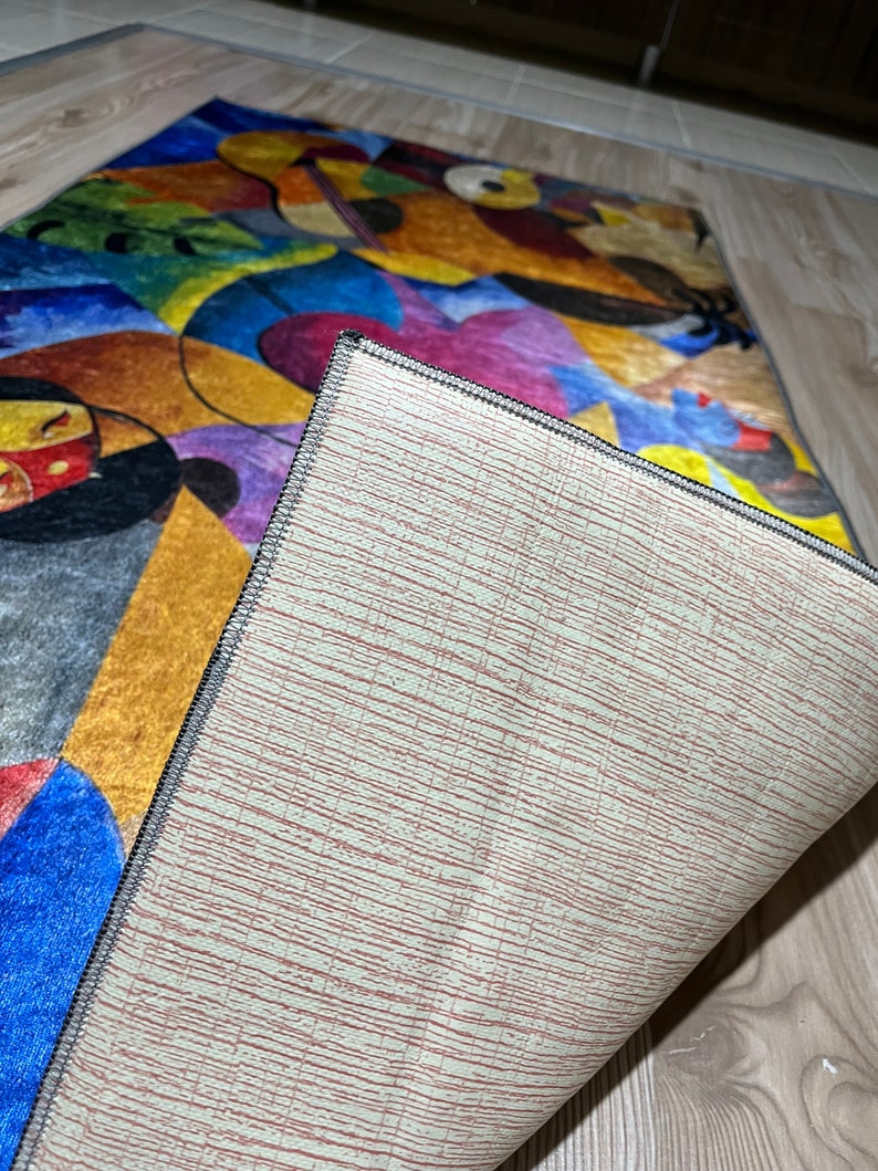 May include: A colorful abstract rug with a geometric design. The rug has a beige backing with a textured pattern.