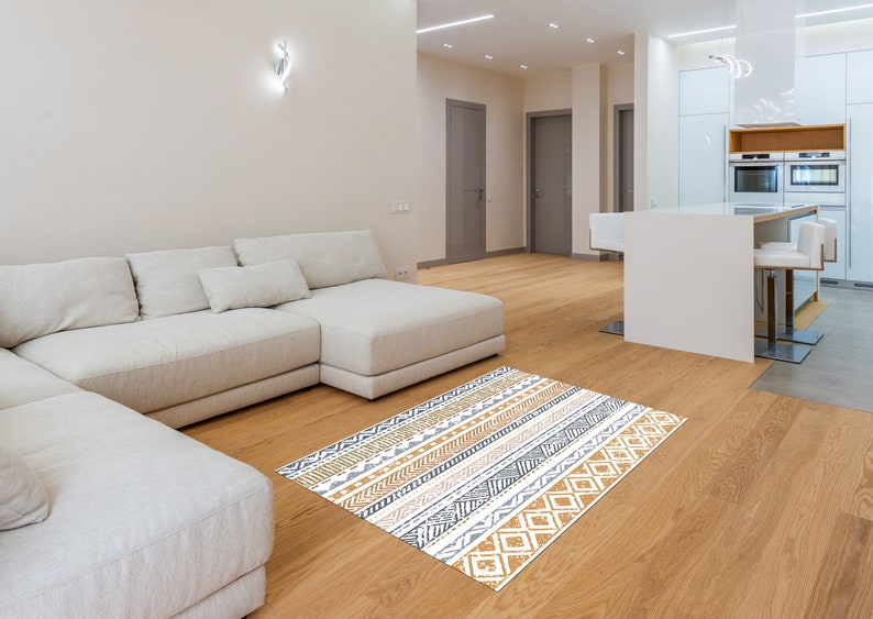 May include: A white sectional sofa with a patterned rug in shades of brown, white, and gray. The rug has a geometric design with stripes and diamonds.