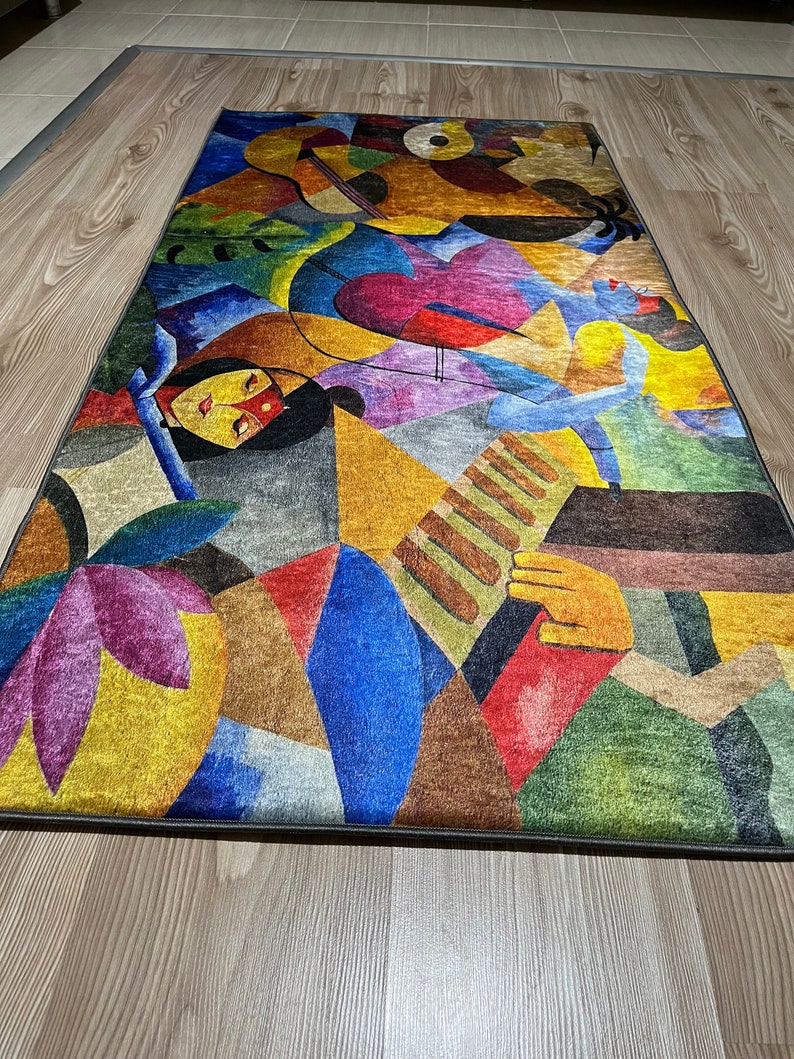 May include: Abstract rug with a colorful geometric design featuring a human figure playing a musical instrument. The rug has shades of blue, yellow, red, green, purple, and brown.