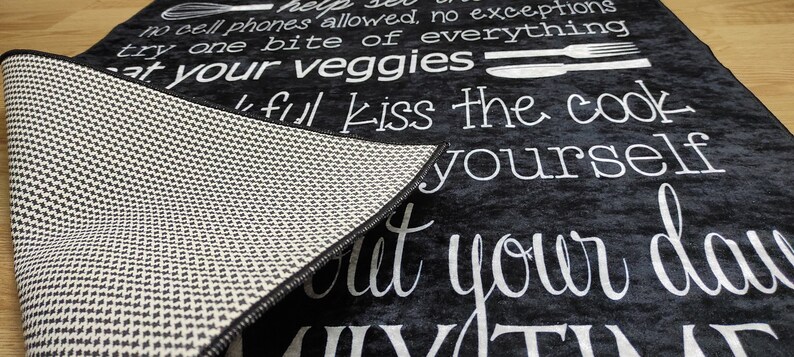 May include: Black and white kitchen rug with the text "Help yourself, no cell phones allowed, no exceptions, try one bite of everything, eat your veggies, kiss the cook, but your day"