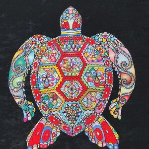 May include: A black rectangular rug featuring a colorful turtle design. The turtle is intricately patterned with red, yellow, blue, and green geometric shapes and floral motifs. White geometric border accents the edges.