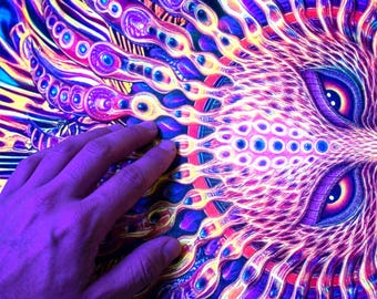 May include: A vibrant tapestry featuring a stylized sun face with intricate, radiating patterns in neon shades of purple, blue, pink, and yellow. The design includes detailed circular motifs and textured lines that create a glowing effect.