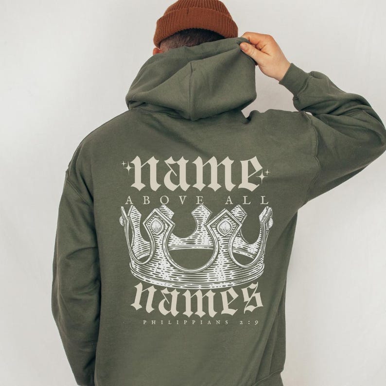 May include: Green hooded sweatshirt with a white graphic print of a crown and the text "name above all names Philippians 2:9"