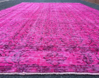 May include: A pink and black patterned rug with a distressed look. The rug has a fringed border.