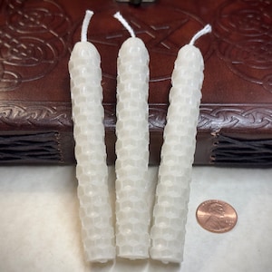 Könnte beinhalten: Drei weiße Bienenwachskerzen, jede etwa 7,5 cm lang, mit einer Wabenstruktur. Die Kerzen sind vertikal angeordnet und befinden sich neben einem deutschen Ein-Cent-Stück zur Größenbestimmung.