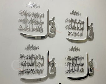 May include: Four silver 3D wall art pieces with Arabic calligraphy and a decorative design. The pieces are mounted on a white wall. The wall art is displayed above a white table with silver vases and a silver bowl.