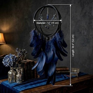 Puede incluir: Atrapasue&ntilde;os negro de 19 cm de di&aacute;metro y 53 cm de largo, con un centro de telara&ntilde;a, plumas azul oscuro y cuentas decorativas. Cuelga de una cadena. Di&aacute;metro: 7,5" (19 cm) y Longitud: 20,9" (53 cm).