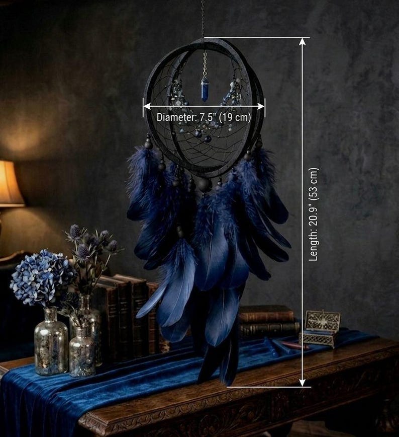 Puede incluir: Atrapasue&ntilde;os negro de 19 cm de di&aacute;metro y 53 cm de largo, con un centro de telara&ntilde;a, plumas azul oscuro y cuentas decorativas. Cuelga de una cadena. Di&aacute;metro: 7,5" (19 cm) y Longitud: 20,9" (53 cm).