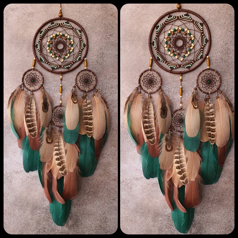 May include: A brown and green dreamcatcher with feathers. The dreamcatcher has a circular design with beads and a web-like pattern. The feathers are brown, green, and white.