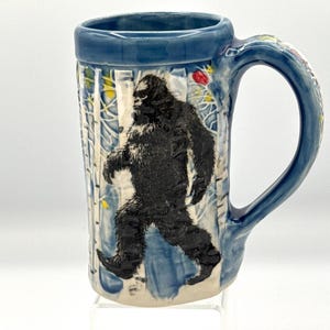 16 oz handmade pottery mug Bigfoot and red birds in the woods