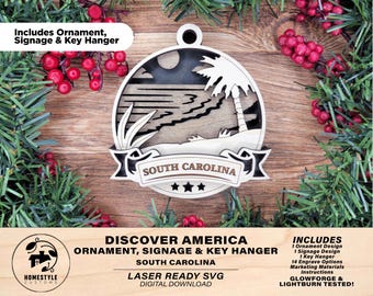 May include: A wooden ornament featuring a beach scene with a palm tree, waves, and the text "SOUTH CAROLINA." The ornament is laser-cut and includes a key hanger and signage design. The design is surrounded by greenery and red berries.