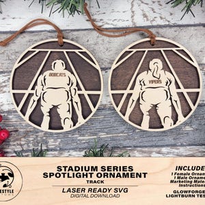 May include: Two laser cut wooden ornaments in the shape of a stadium spotlight. The ornaments feature a silhouette of a person in a sports uniform with the team names "Bobcats" and "Vipers" on the back. The ornaments are designed for laser cutting and are Glowforge and Lightburn tested.