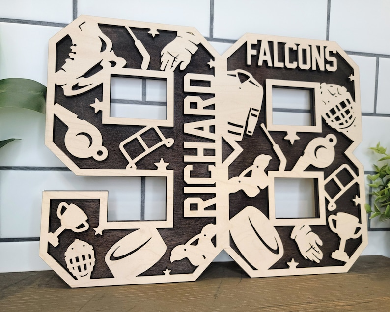 Peut inclure: Une d&eacute;coupe en bois du num&eacute;ro 98 avec des images sur le th&egrave;me du hockey. Le num&eacute;ro est peint en brun et les images sont en bois naturel. Le nom "RICHARD" est &eacute;crit verticalement sur le c&ocirc;t&eacute; gauche du num&eacute;ro et "FALCONS" est &eacute;crit horizontalement en haut du num&eacute;ro.
