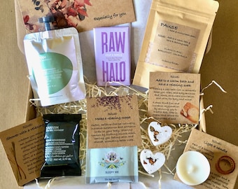 May include: A gift box filled with self-care items, including a bar of chocolate, bath salts, a tea bag, soap, and a candle. The box is decorated with a brown paper and a floral design. The text on the box reads "Especially for you".