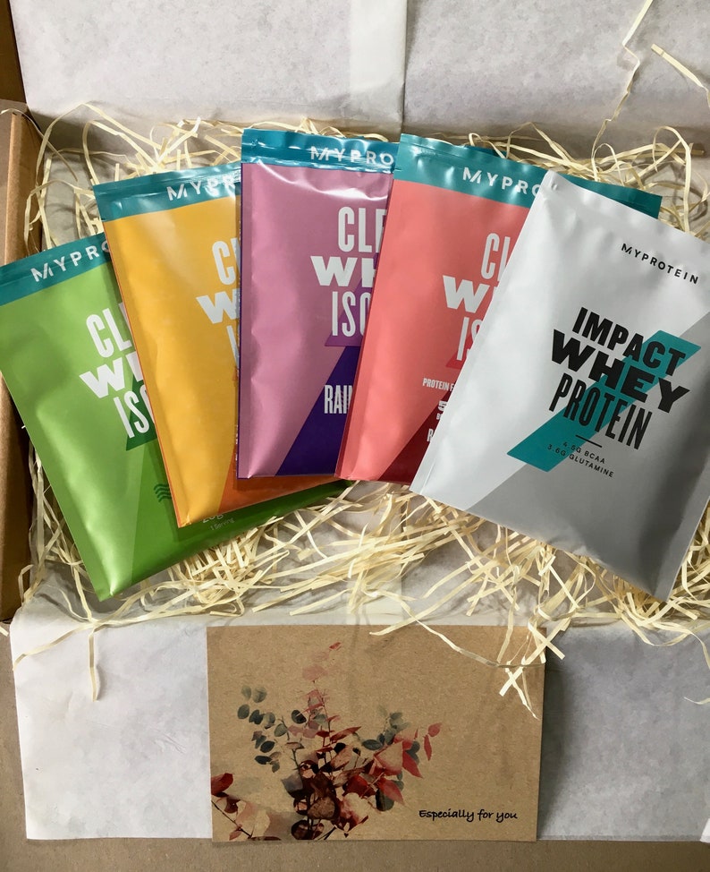May include: A selection of Myprotein protein powder sachets in a box. The sachets are in various colours, including green, yellow, pink, and white. The box also contains decorative straw and a card with the text "Especially for you".